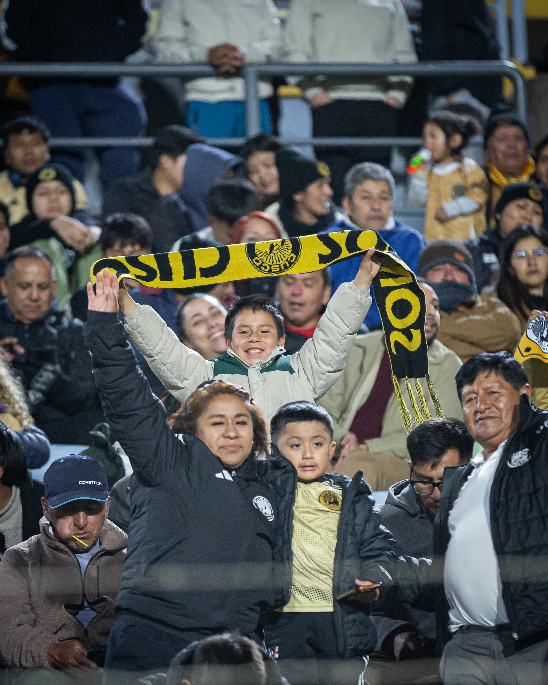 Aficionados de Cusco FC sostienen una bufanda en la tribuna